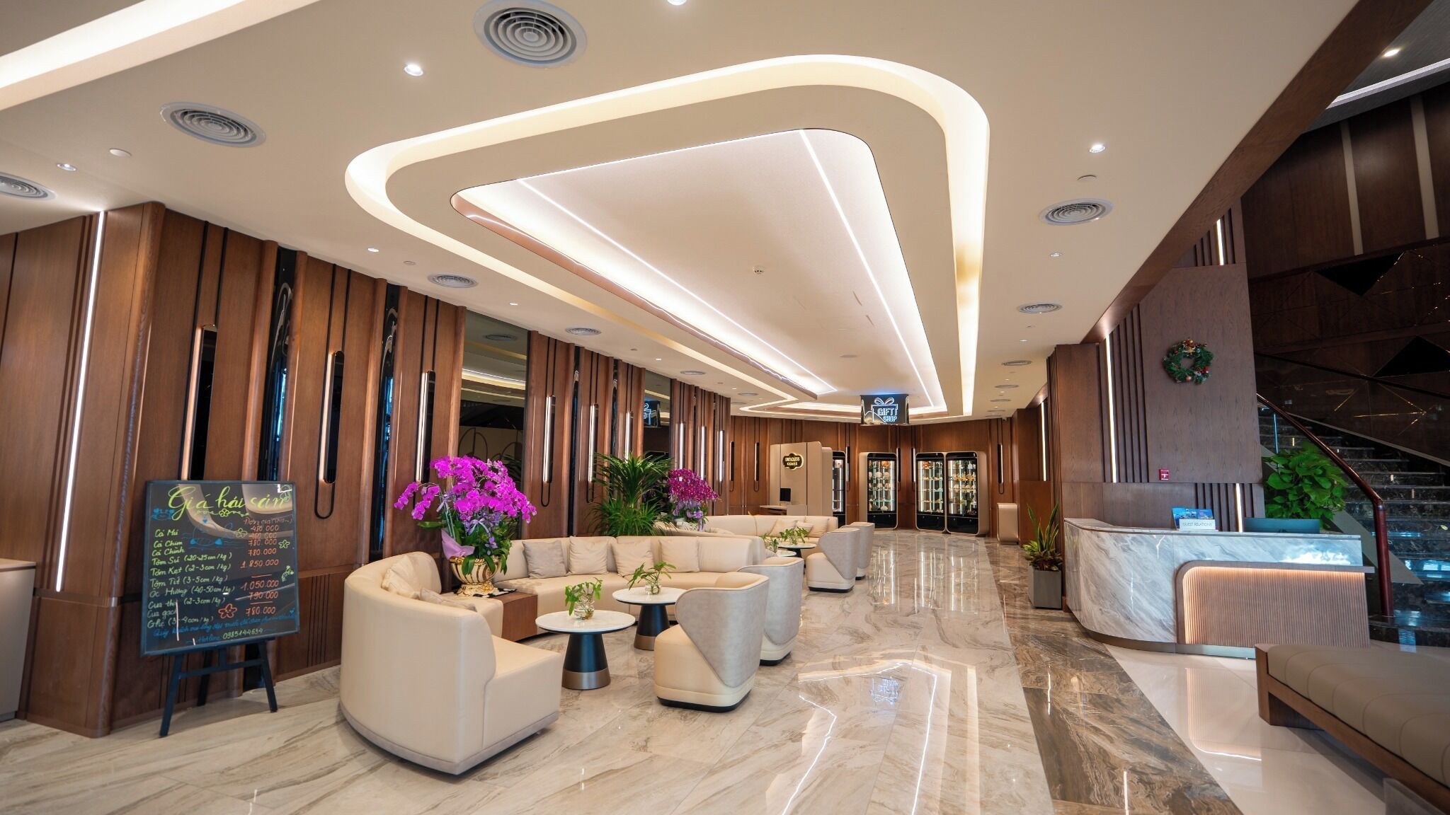 A modern hotel lobby with a reception desk, seating area, and a menu board.