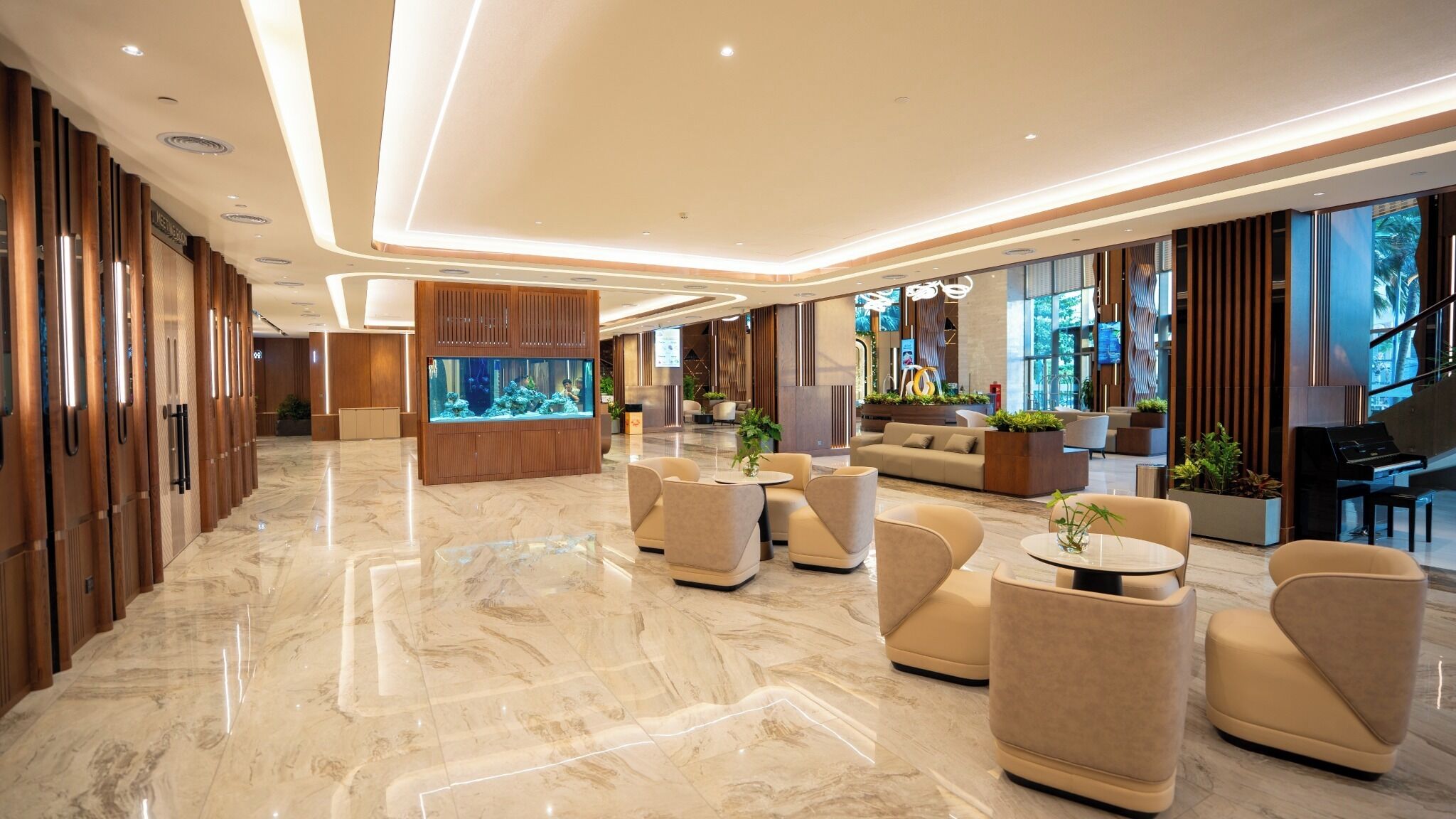 A spacious lobby with a large aquarium, comfortable seating, and a grand piano.