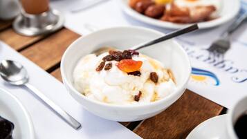 Un bol de postre con crema batida y fruta sobre una mesa de madera.