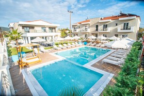 Piscine extérieure en saison, parasols, chaises longues