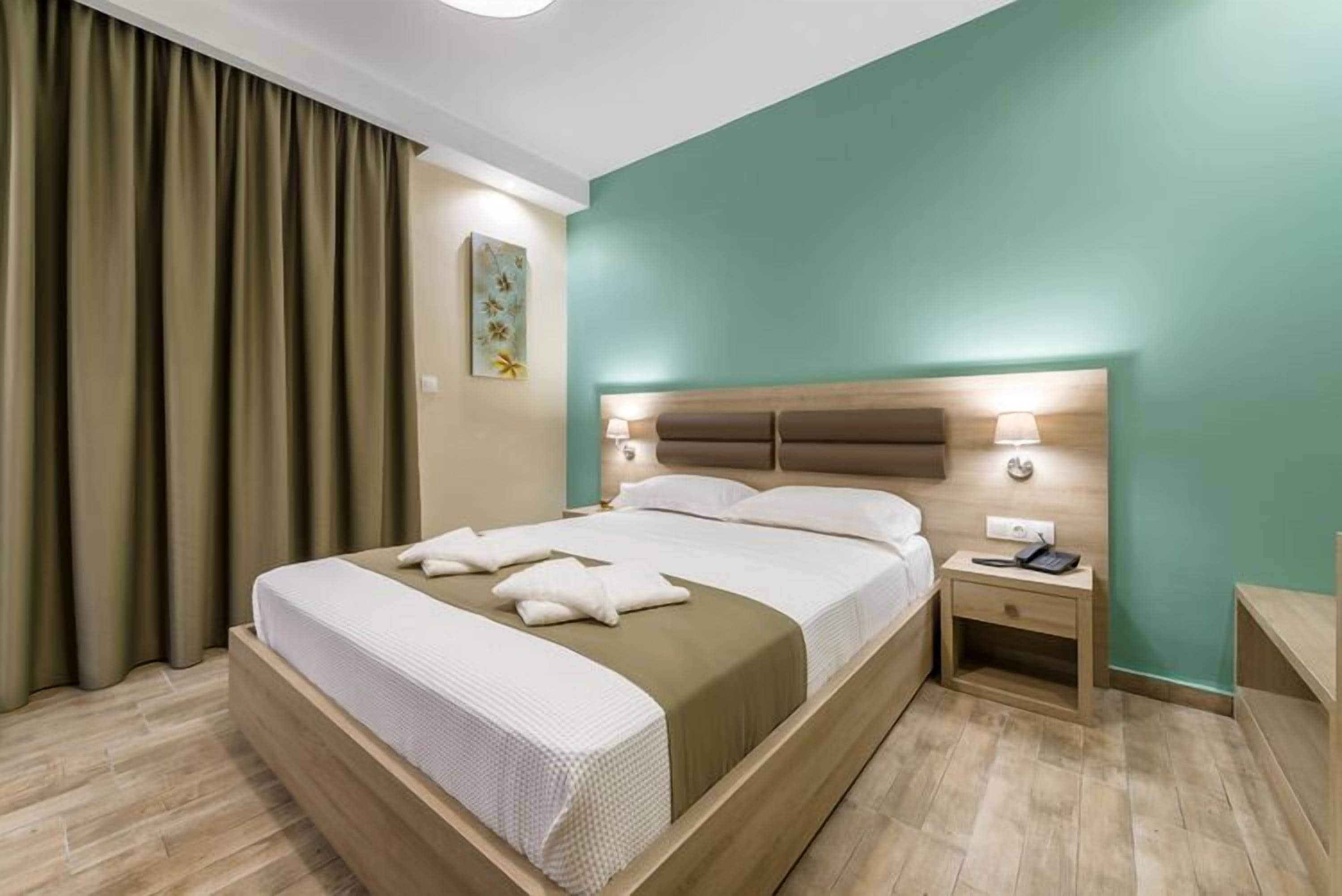 Ein Hotelzimmer mit Bett, Nachttisch und Wandlampe.