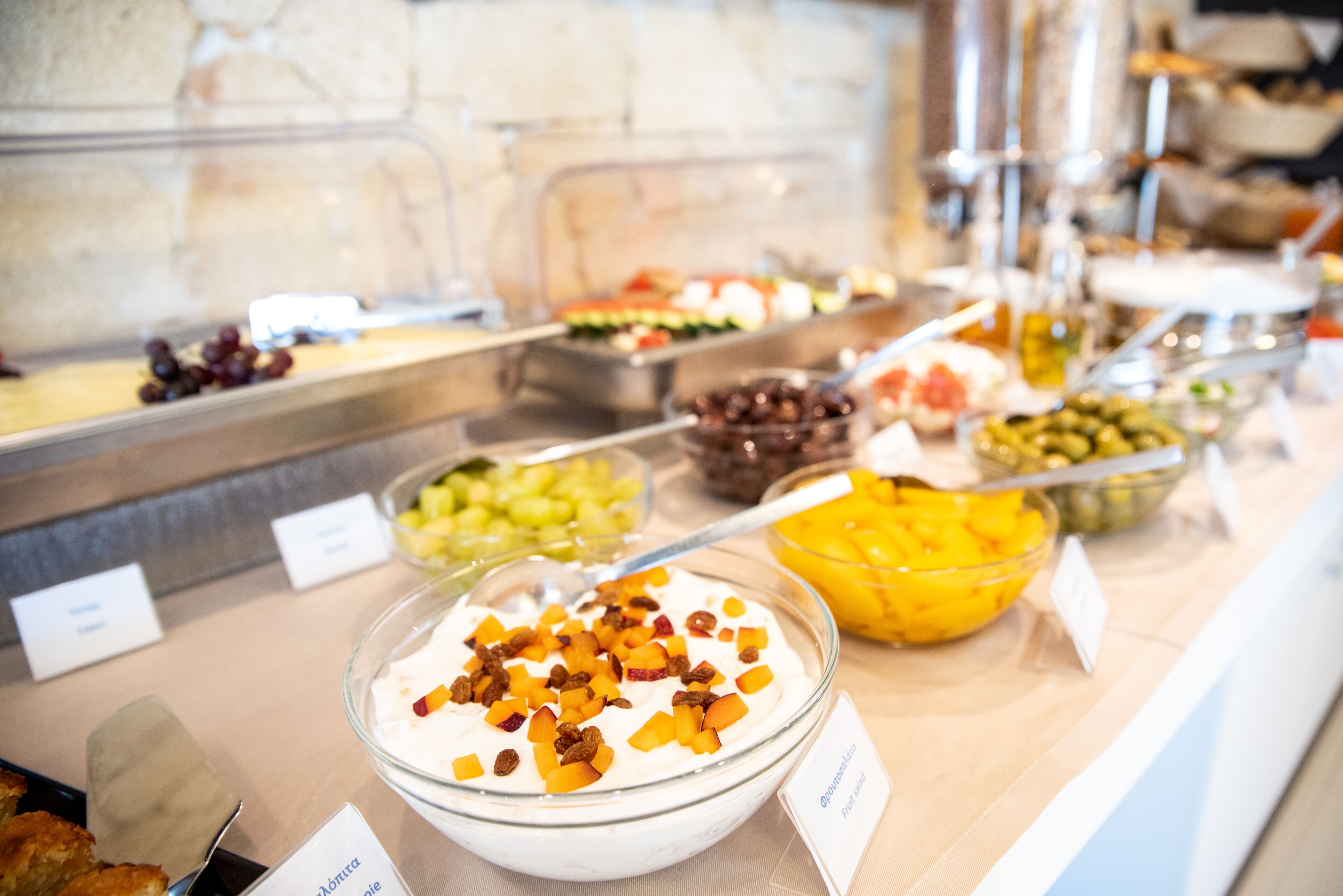 A buffet with various food options including fruits, nuts, and yogurt.