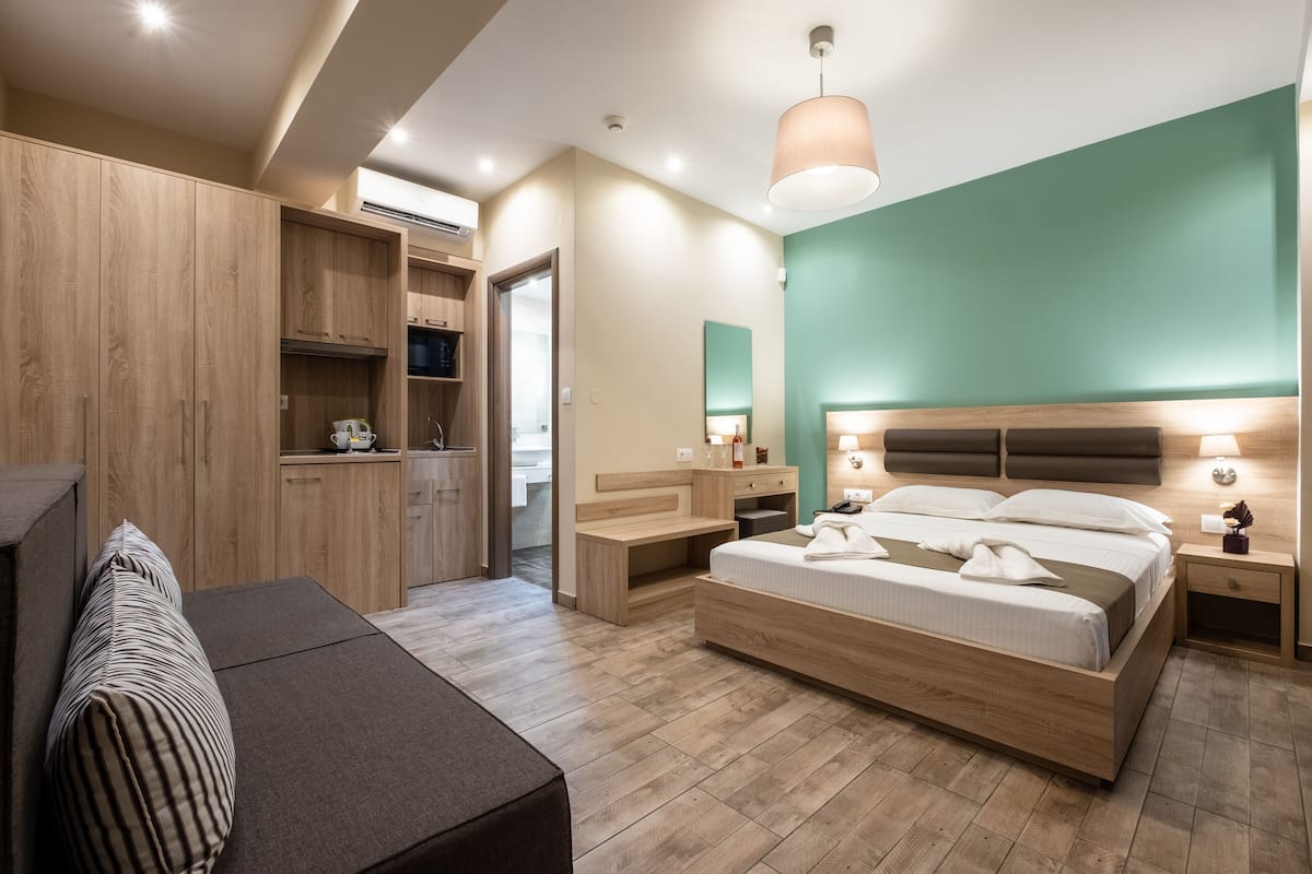 A modern bedroom with a wooden bed, bedside tables, a desk, and a wardrobe.
