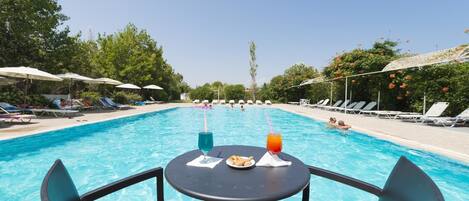 Una piscina al aire libre de temporada, sombrillas