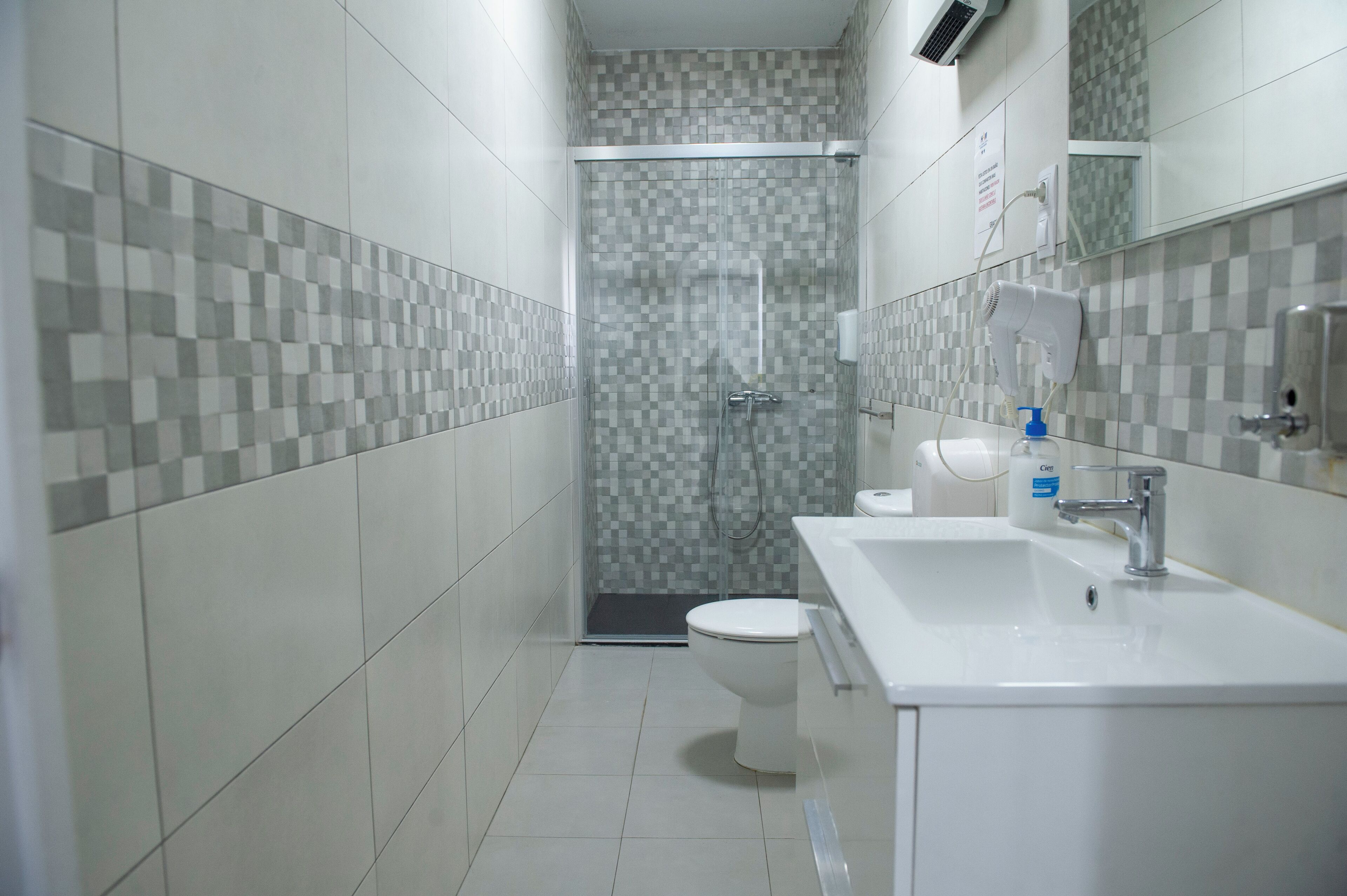 Un baño con ducha, inodoro y lavamanos.