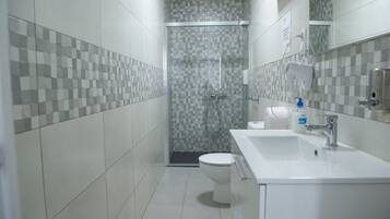 Un baño con ducha, inodoro y lavamanos.