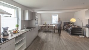 Una cucina moderna con zona pranzo, divano e televisione.