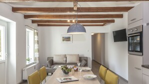 Una cucina moderna con forno a incasso, un tavolo da pranzo con sedie e una lampada a sospensione.
