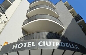 The exterior of Hotel Ciutadella with a modern design, featuring multiple balconies and a clear sky. - Hotel Ciutadella (Roses)
