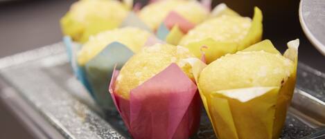 A tray of colorful cupcakes with a dusting of powdered sugar.