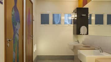 Un baño moderno con dos lavamanos, un espejo y un armario empotrado.