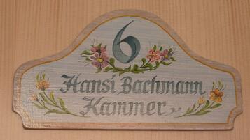 A wooden sign with the number 6 and the name "Hansi Bachmann" along with "Kammer".