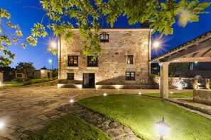A stone building with a courtyard, illuminated by street lamps. - Casal dos Celenis (Caldas de Reis)