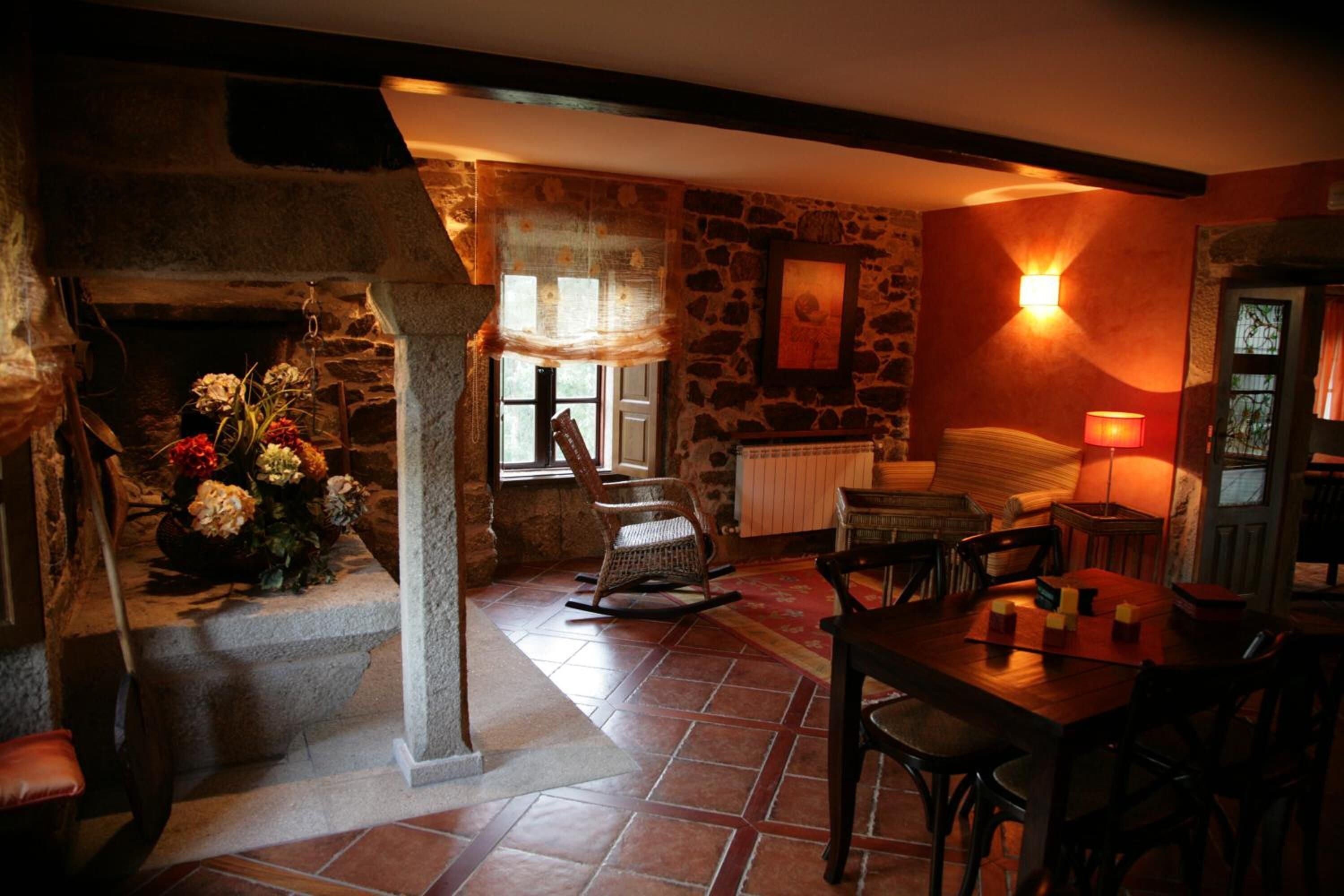 A cozy room with a stone fireplace, a wooden table, and a comfortable seating area.