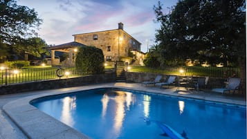 Una piscina al aire libre de temporada, sombrillas