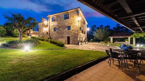 A stone building with a patio and outdoor seating area. - Casal dos Celenis (Caldas de Reis)