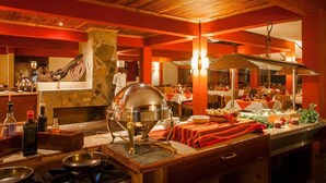 A restaurant with a buffet setup, wooden ceiling, and a stone wall. - Mara Leisure Camp (Maasai Mara)