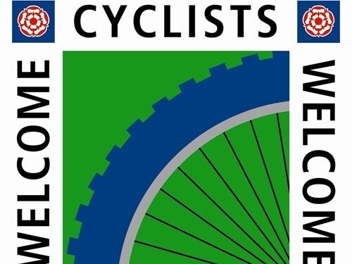 Un logotipo con las palabras 'CYCLISTS' y 'WELCOME' sobre un fondo verde, que incluye un engranaje azul y una flor roja.