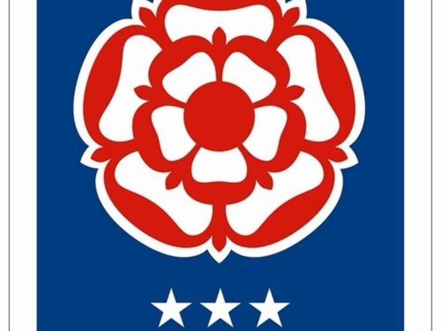 Una bandera con un diseño similar a una flor en rojo y blanco, y tres estrellas blancas.