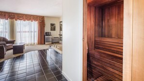 Una sala de estar moderna con sofá, mesa de centro y un gran ventanal con cortinas.