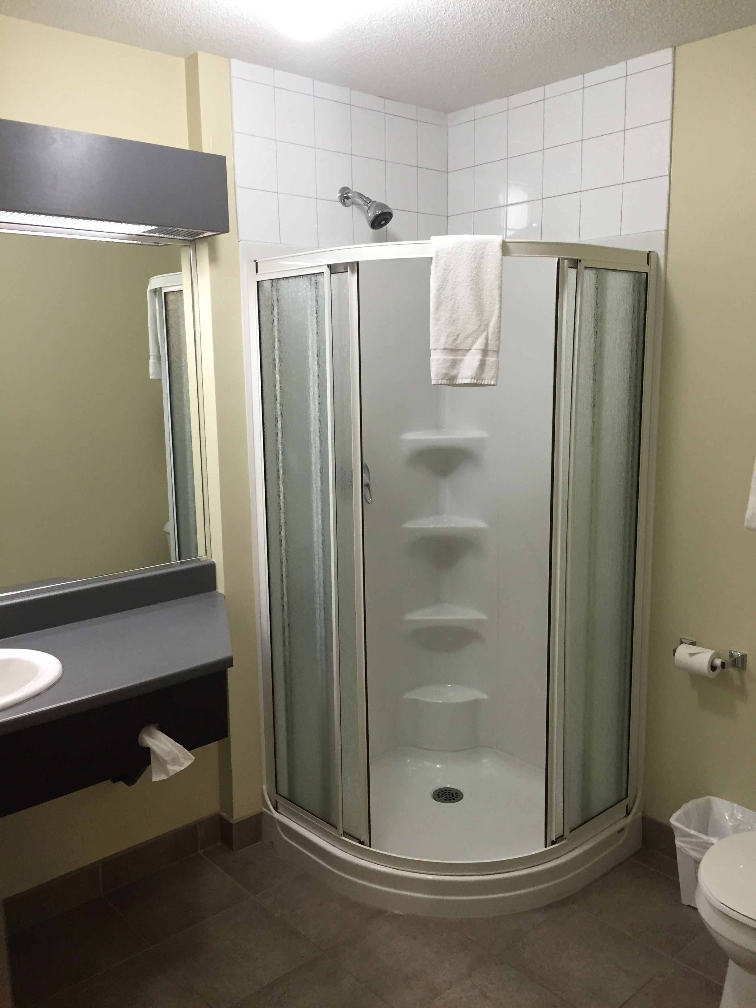 A bathroom with a glass-enclosed shower, a sink, and a toilet.