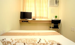 A hotel room with a bed, a desk with a computer monitor, a telephone, and a chair. - Anri Pension House (Cebu City)