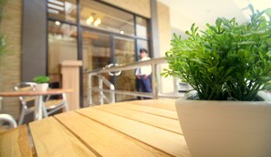 A wooden table with a potted plant in the foreground. - Anri Pension House (Cebu City)