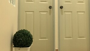 Two white doors with numbers 207 and 208, a potted plant, and a light-colored floor. - Anri Pension House (Cebu City)