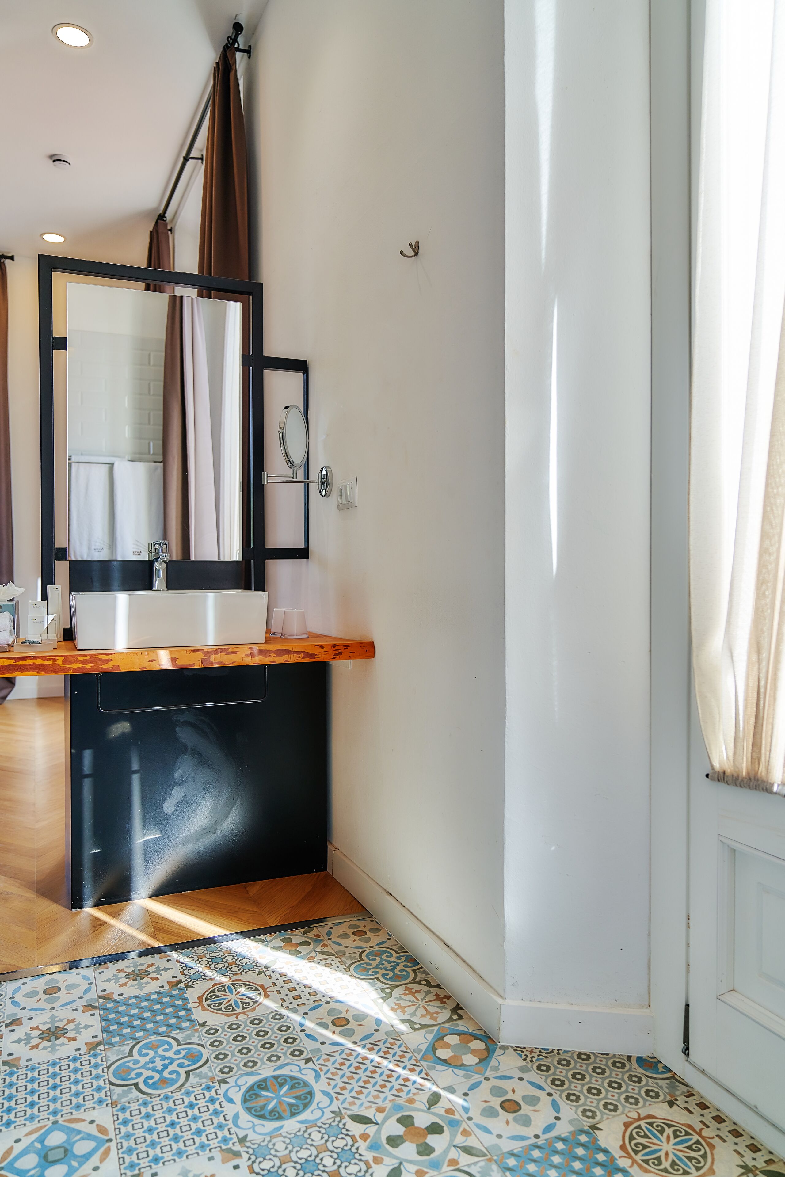 Un baño con lavamanos blanco, espejo y cortina de ducha.