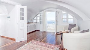 Un loft espacioso con techos altos, una zona de cocina y un área de descanso con vistas al mar.