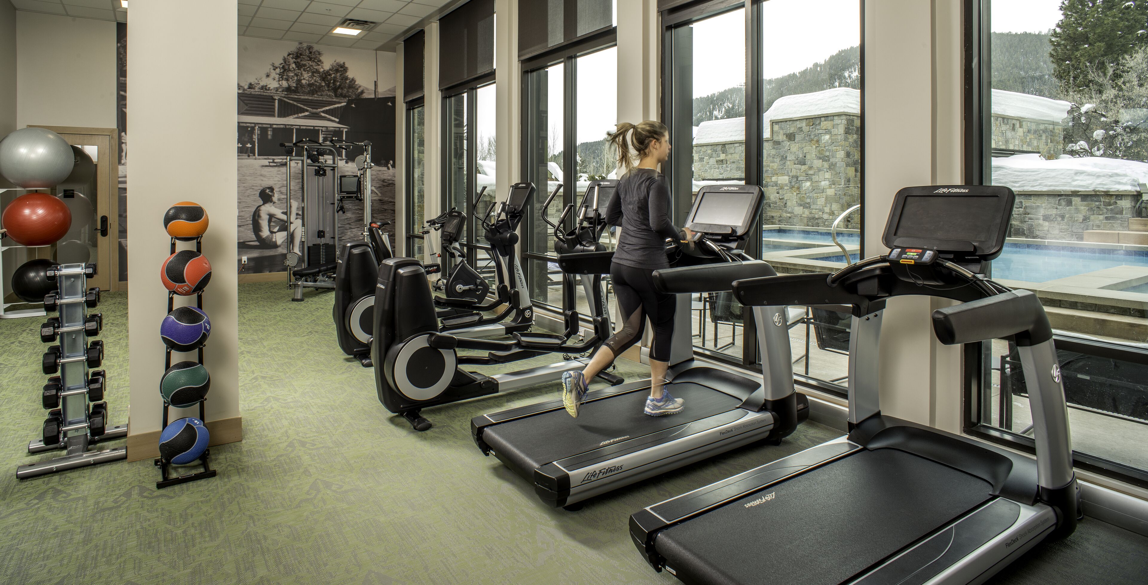 A gym with treadmills, exercise balls, and weight machines.