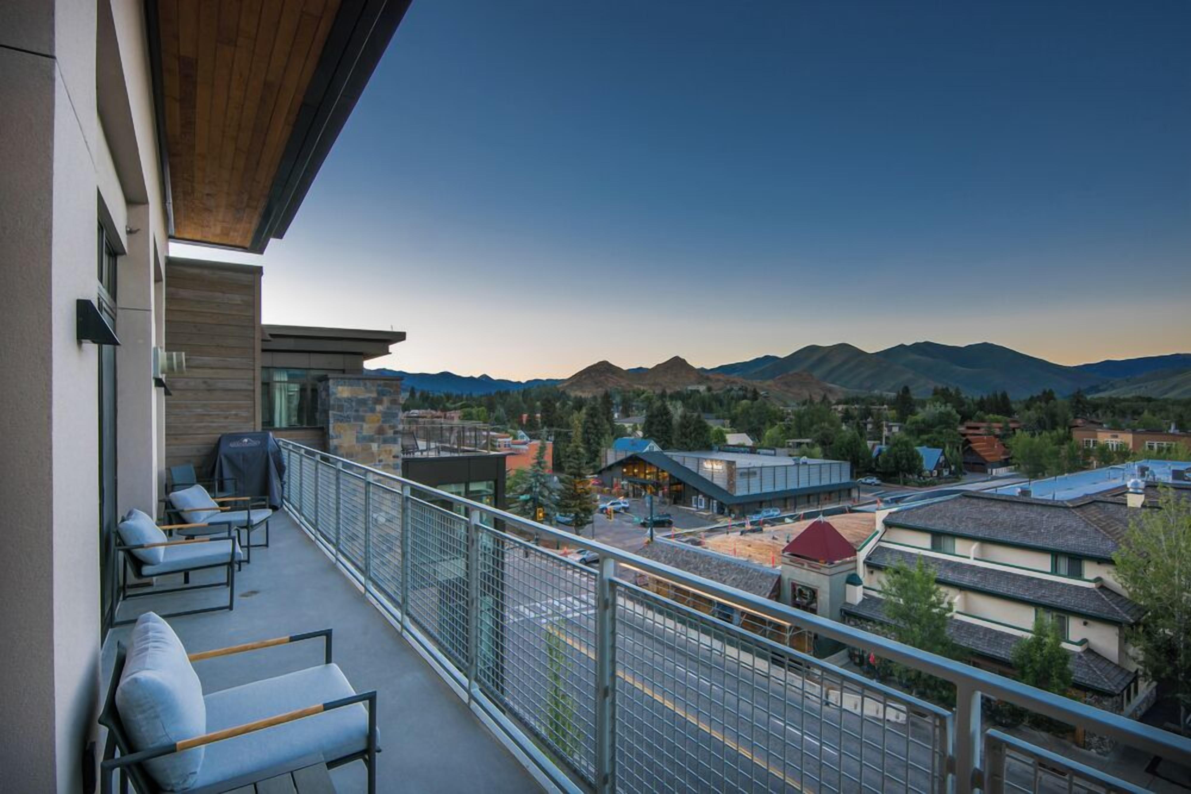 Un balcon avec un espace salon extérieur et une vue sur les montagnes.
