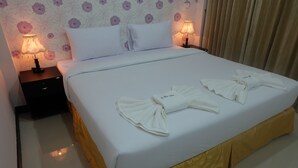 A hotel room with a neatly made bed, two bedside lamps, and floral wallpaper. - PhuTubkaek View House (Krabi)