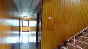 A hallway with wooden paneling, a staircase with metal railings, and a door at the end. - PhuTubkaek View House (Krabi)