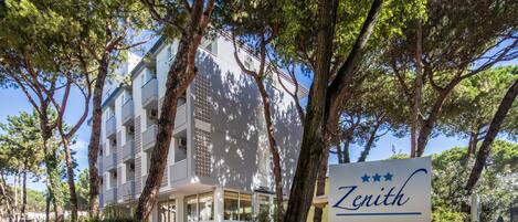 A building with a sign reading "Zenith" surrounded by trees.