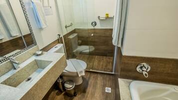 A bathroom with a glass-enclosed shower, a toilet, and a sink.