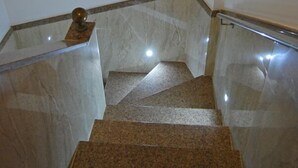 Una escalera con escalones de mármol y barandillas de metal.