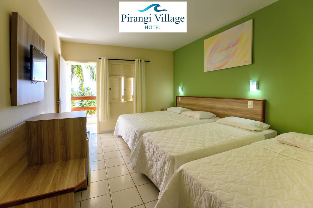 A hotel room with three beds, a wooden bench, a TV, and a green wall with a painting.