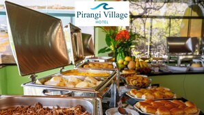 Un bufé con diferentes opciones de comida y el logotipo del Hotel Pirangi Village.