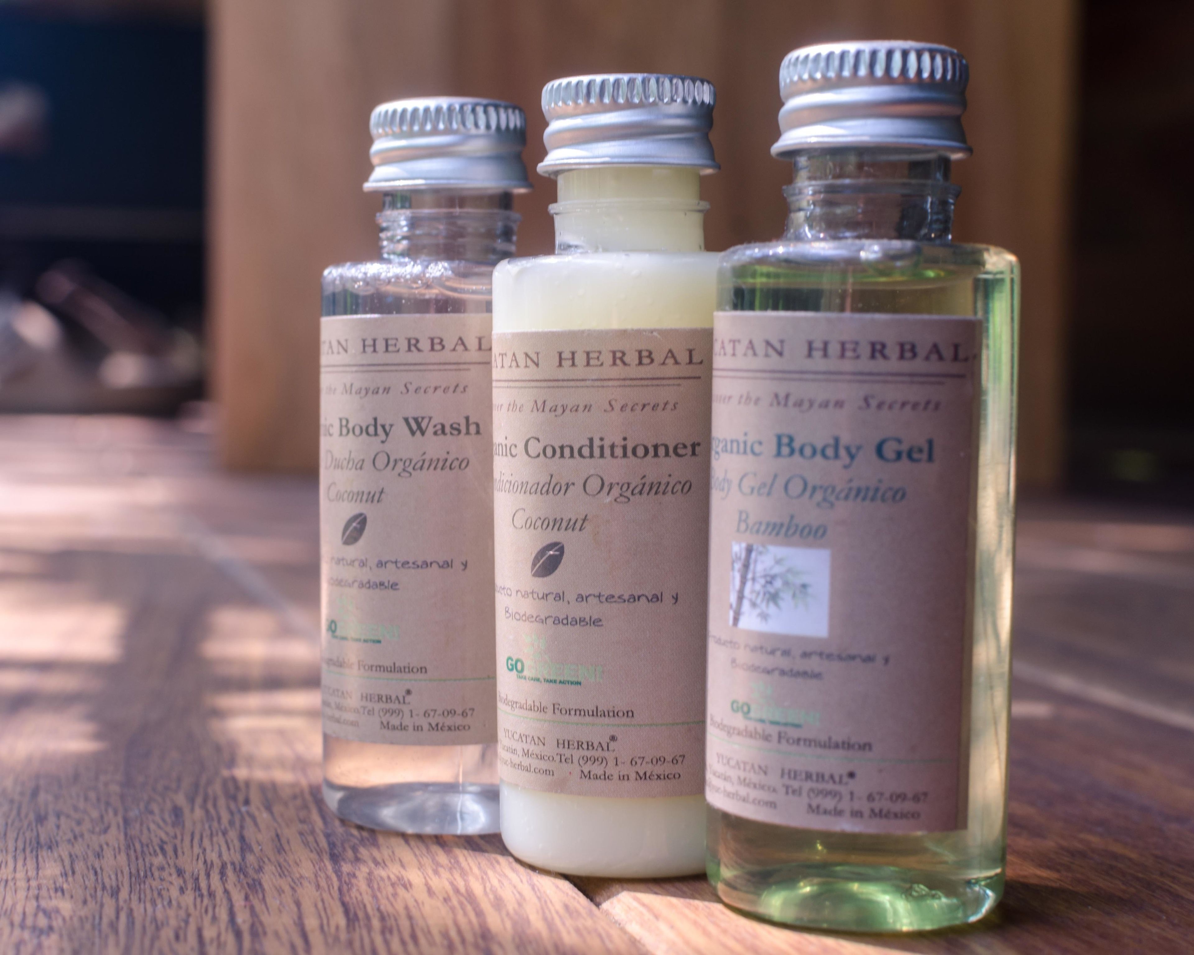 Three bottles of organic body wash on a wooden surface.