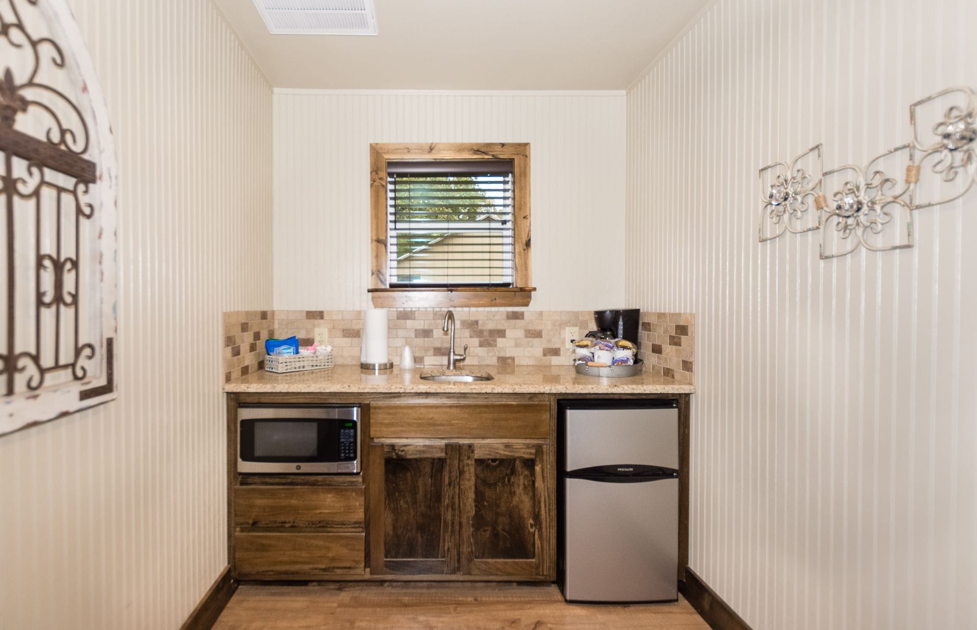 A compact kitchen with a microwave, refrigerator, and sink.
