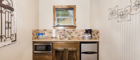 A compact kitchen with a microwave, refrigerator, and sink.