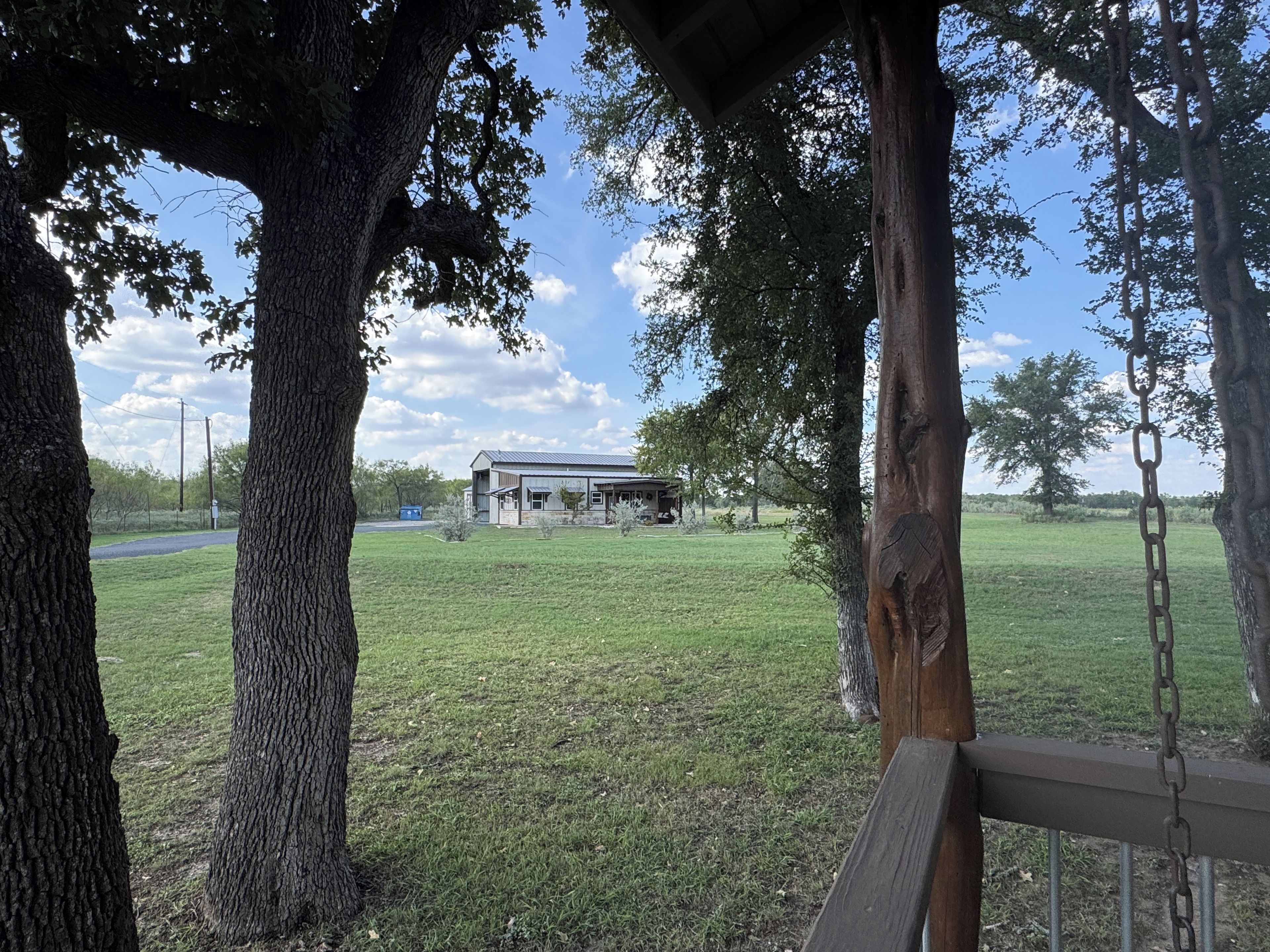 A grassy area with a building and trees.