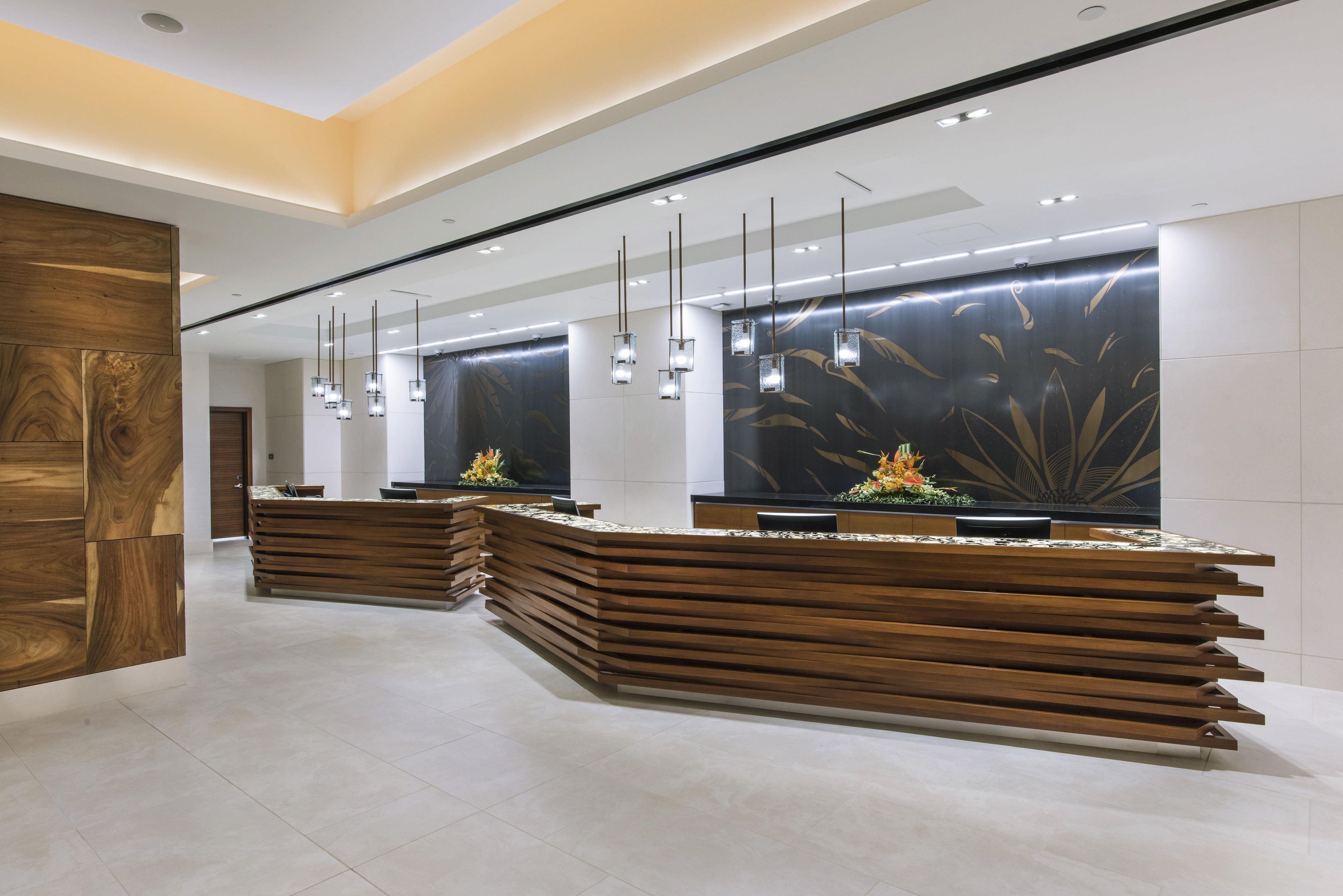 Una recepción con diseño moderno, con detalles de madera y una planta decorativa.