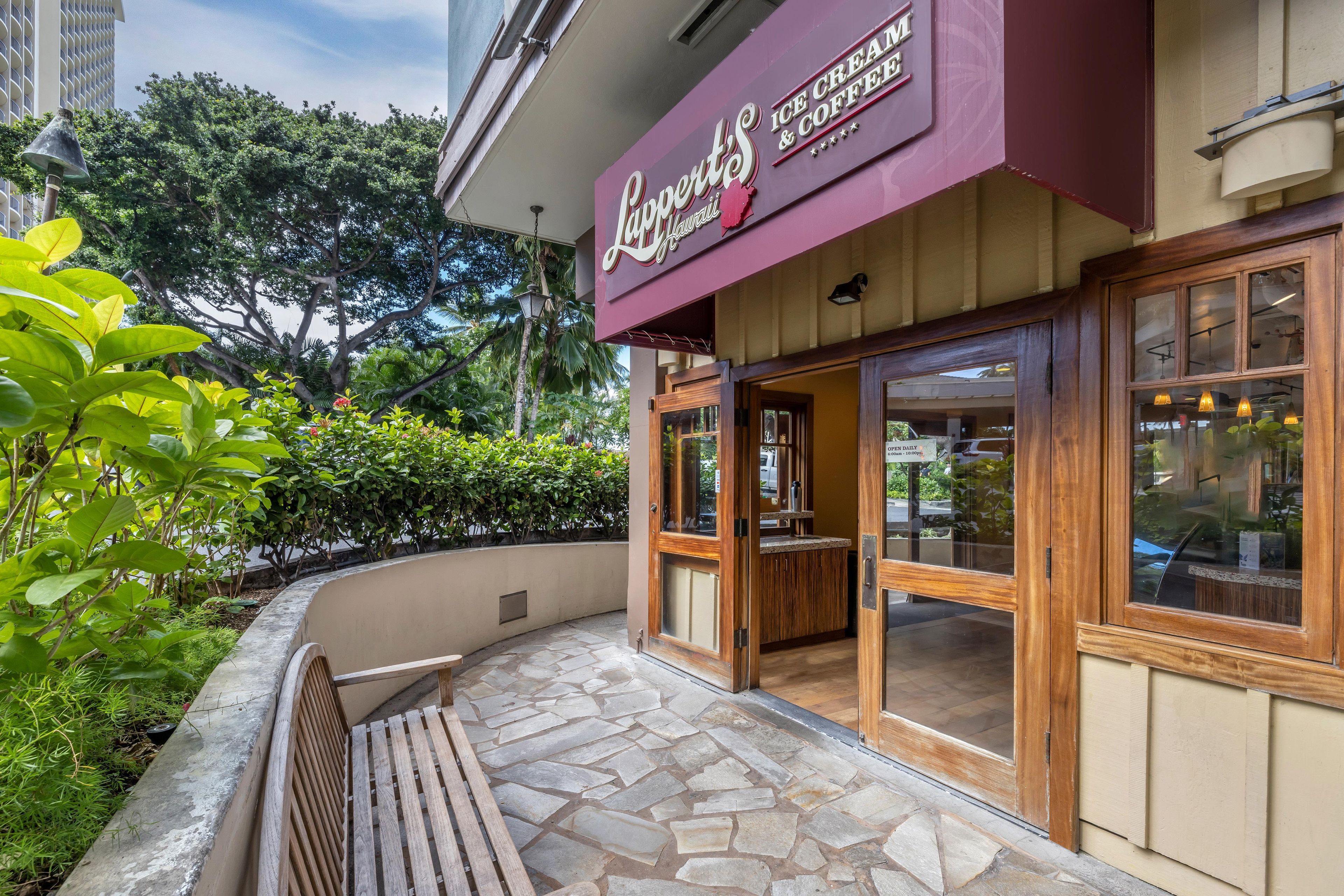 A cafe with a stone-tiled patio and a wooden bench.