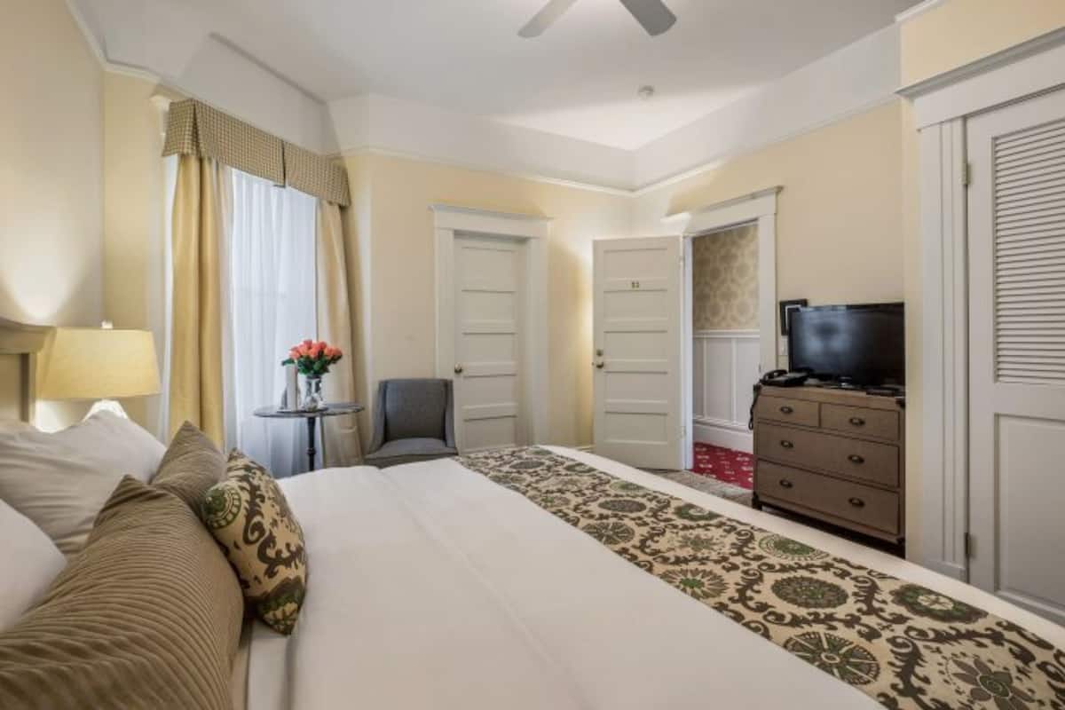 Una camera d'albergo con un letto, una televisione, una cassettiera e una sedia.