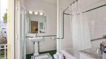 A bathroom with a white sink, mirror, and shower curtain.