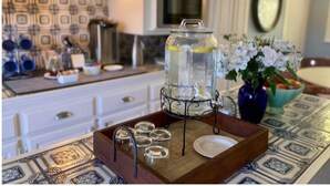 A kitchen with white cabinets, a microwave, and a decorative tray with a glass jar and flowers. - Parker Guest House San Francisco (San Francisco)