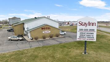 A StayInn motel with a signboard advertising great rooms, daily & weekly prices, and free fast internet.