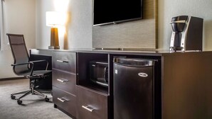 A hotel room with a desk, a flat-screen TV, a coffee maker, and a microwave. - Sleep Inn & Suites Syracuse Airport (East Syracuse)